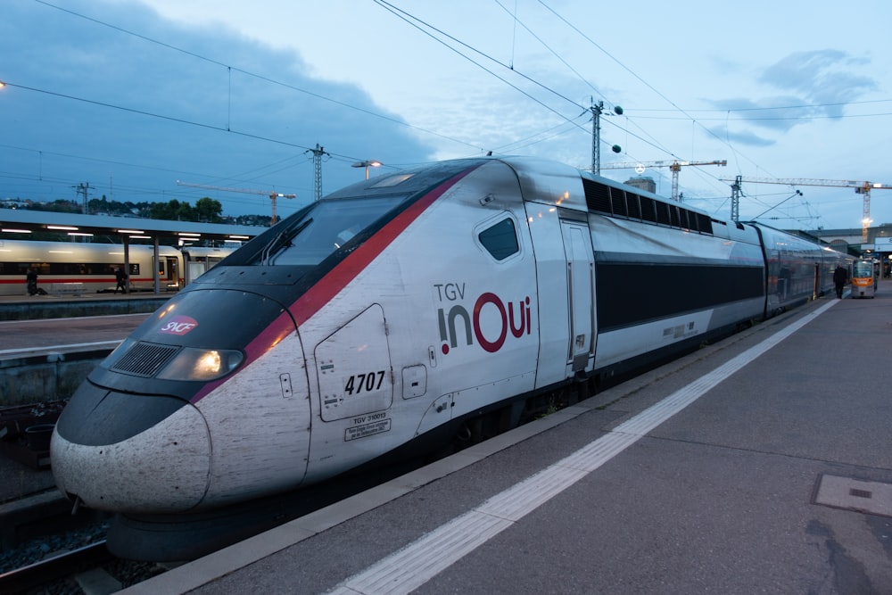 white and red train on rail road during daytime