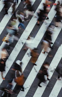 High-contrast black and white shot of a busy crosswalk with blurred motion.