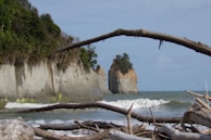 A scenic coastal view with waves crashing against rocky cliffs.