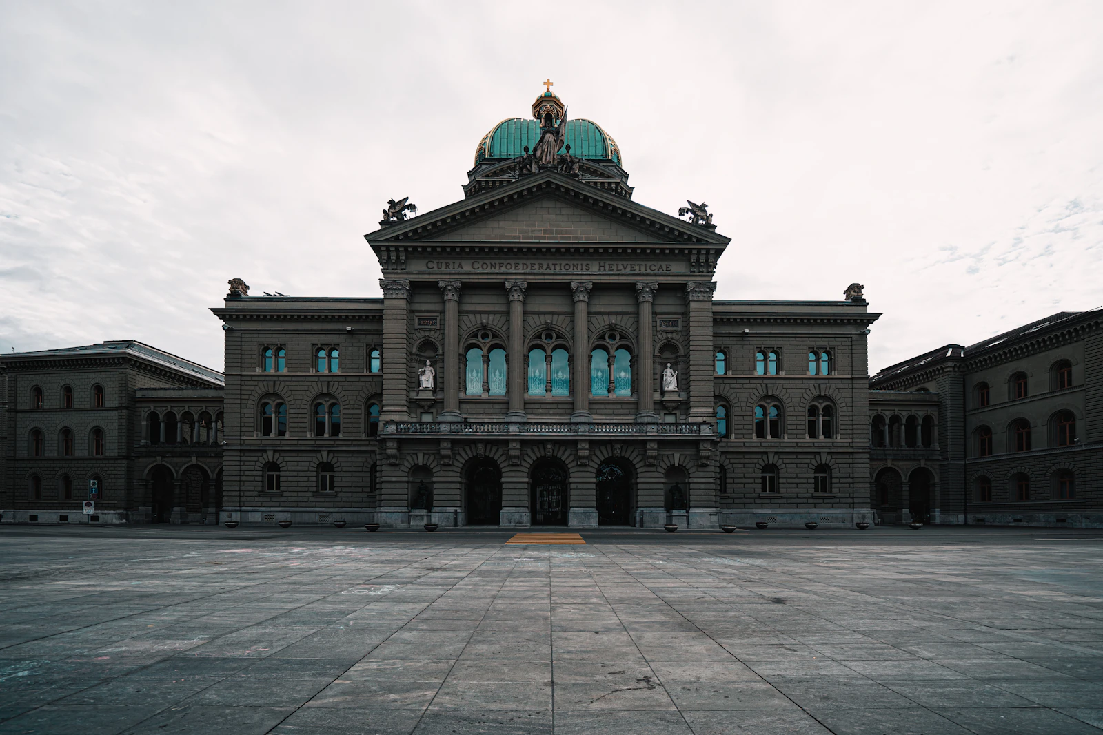 Le Palais fédéral à Berne, siège de l'Assemblée fédérale suisse.e Palais fédéral à Berne, siège de l'Assemblée fédérale suisseVue de la façade du Palais Fédéral en Suisse, avec son dôme vert et des sculptures surLe Palais fédéral à Berne, où le Conseil national débat cette semaine du contre-projet à l'initiative pour l'inclusion la façade, sur une place pavée.