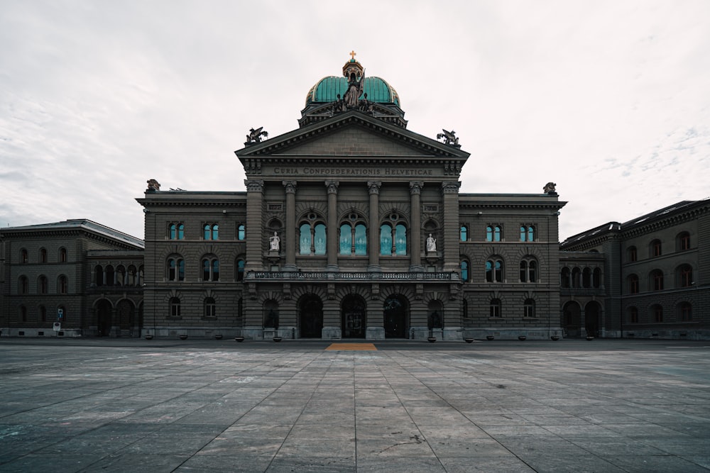 Braunes und grünes Betongebäude unter weißen Wolken tagsüber