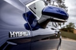 Close-up of a mechanic inspecting a hybrid vehicle’s battery system.