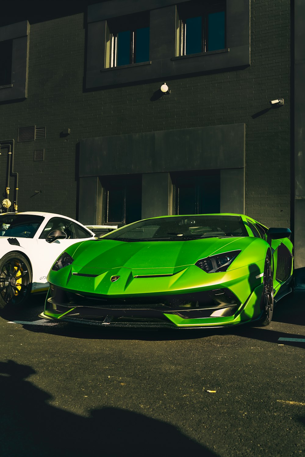 green ferrari sports car parked beside building