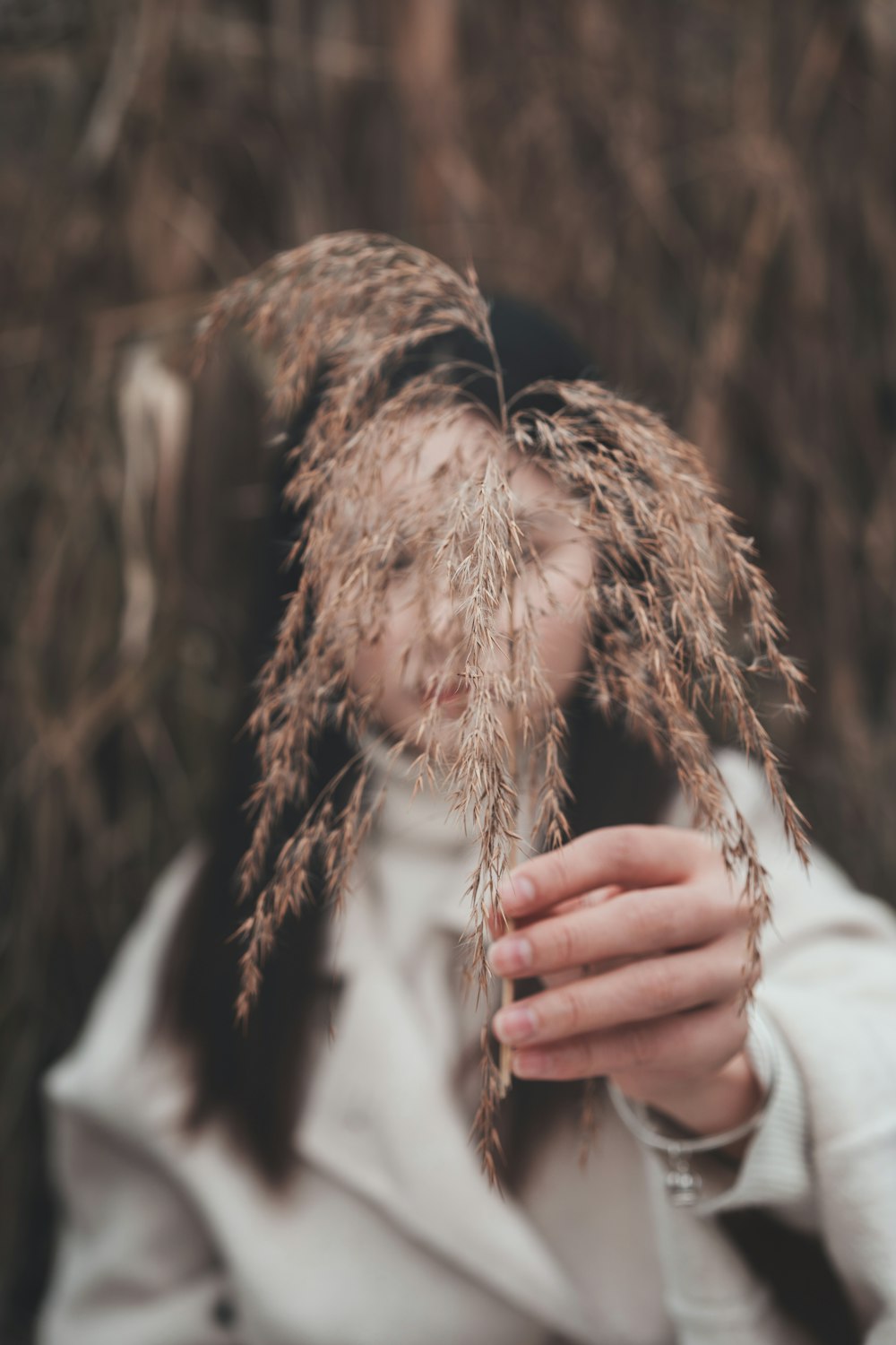 person in white long sleeve shirt holding brown fur textile