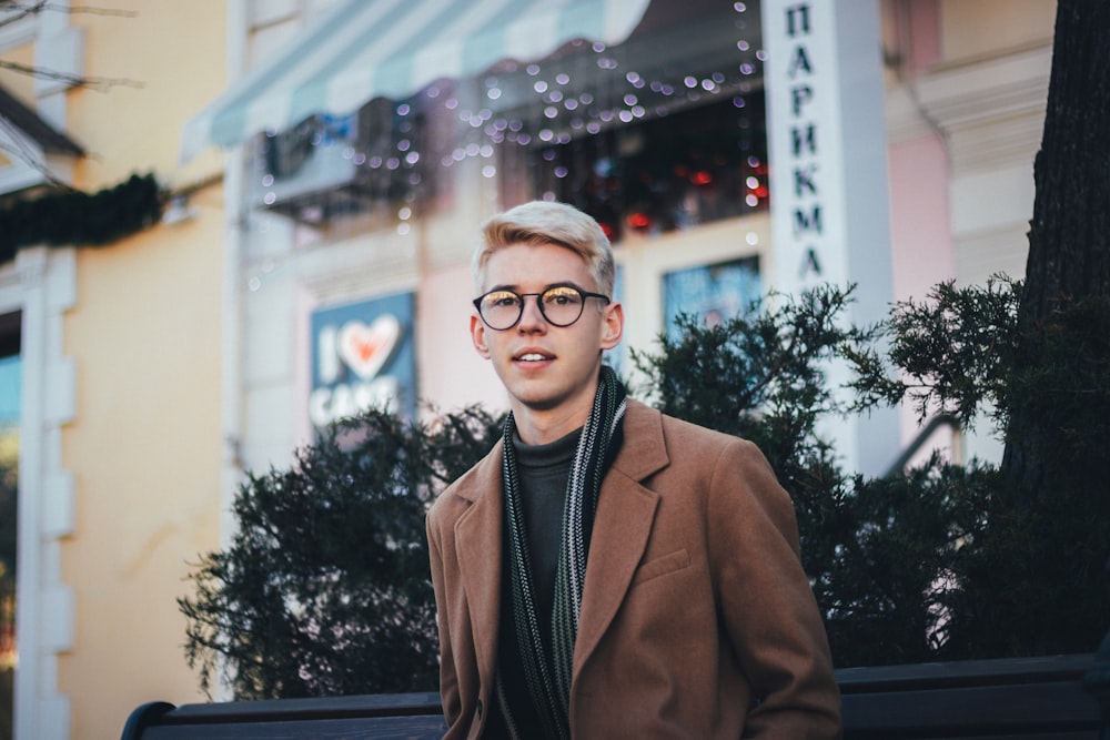 man in brown suit jacket wearing black framed eyeglasses