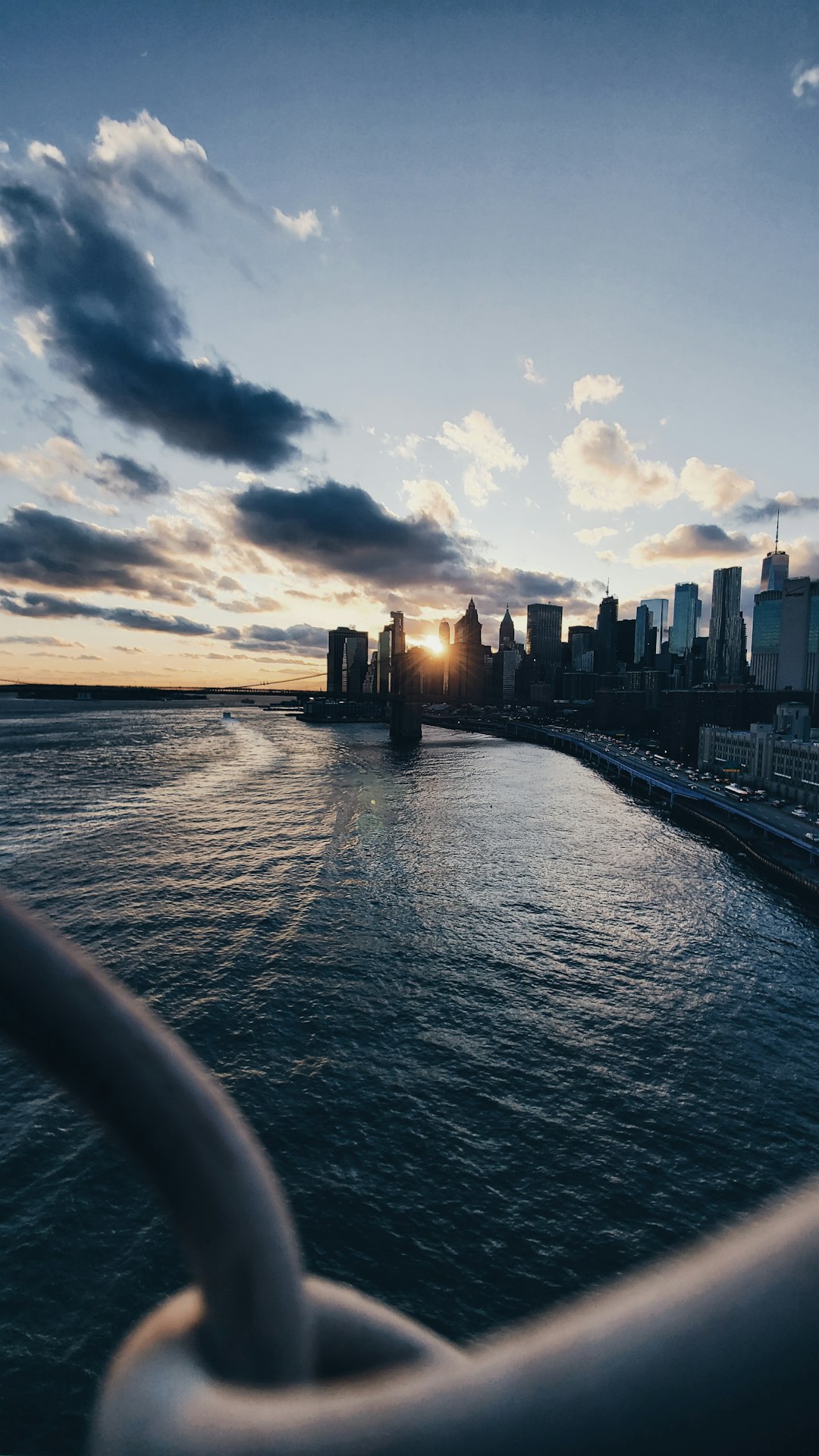 city skyline across body of water during sunset