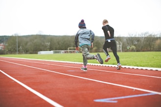 man in black jacket and green pants playing cricket during daytime