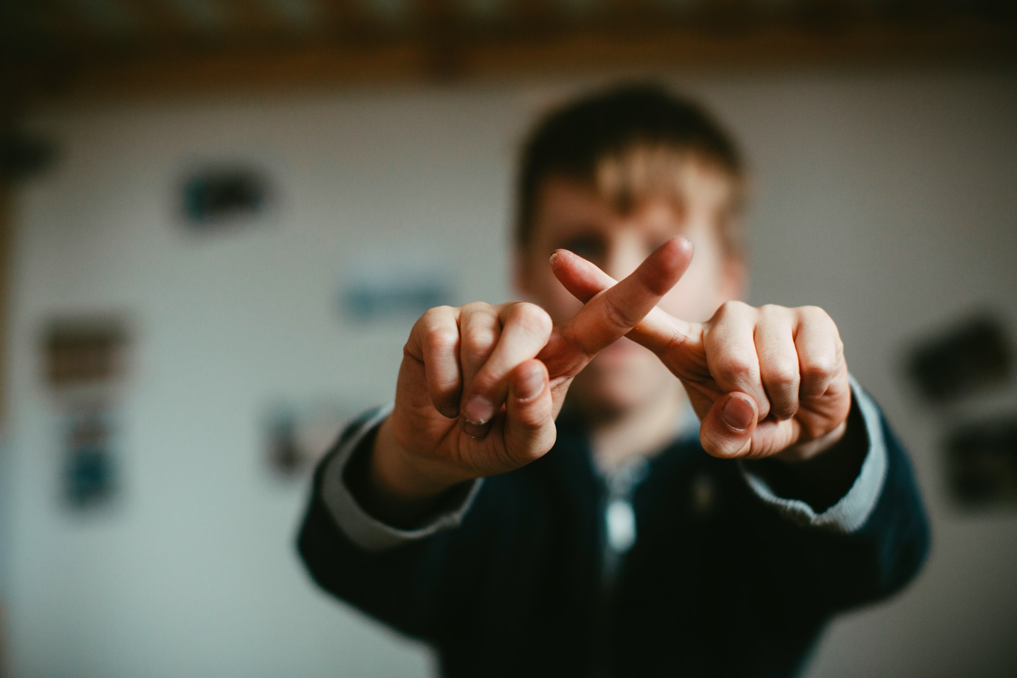 Young boy shows cross with fingers - don't touch me