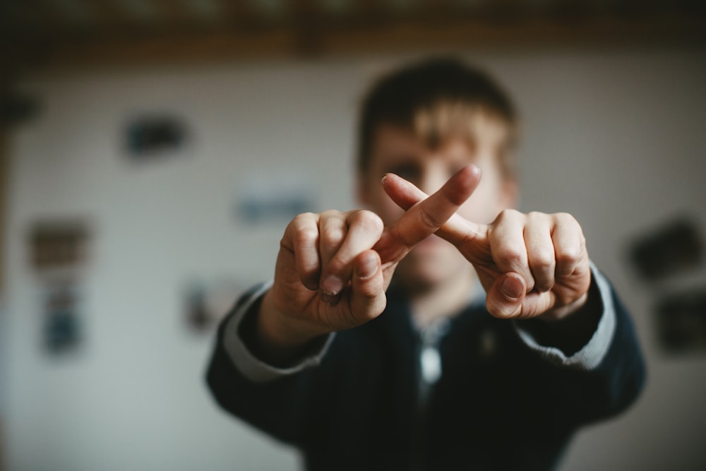 man in black and white jacket doing peace sign