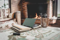 A cozy fireplace with a pair of reading glasses and a notebook filled with story ideas.