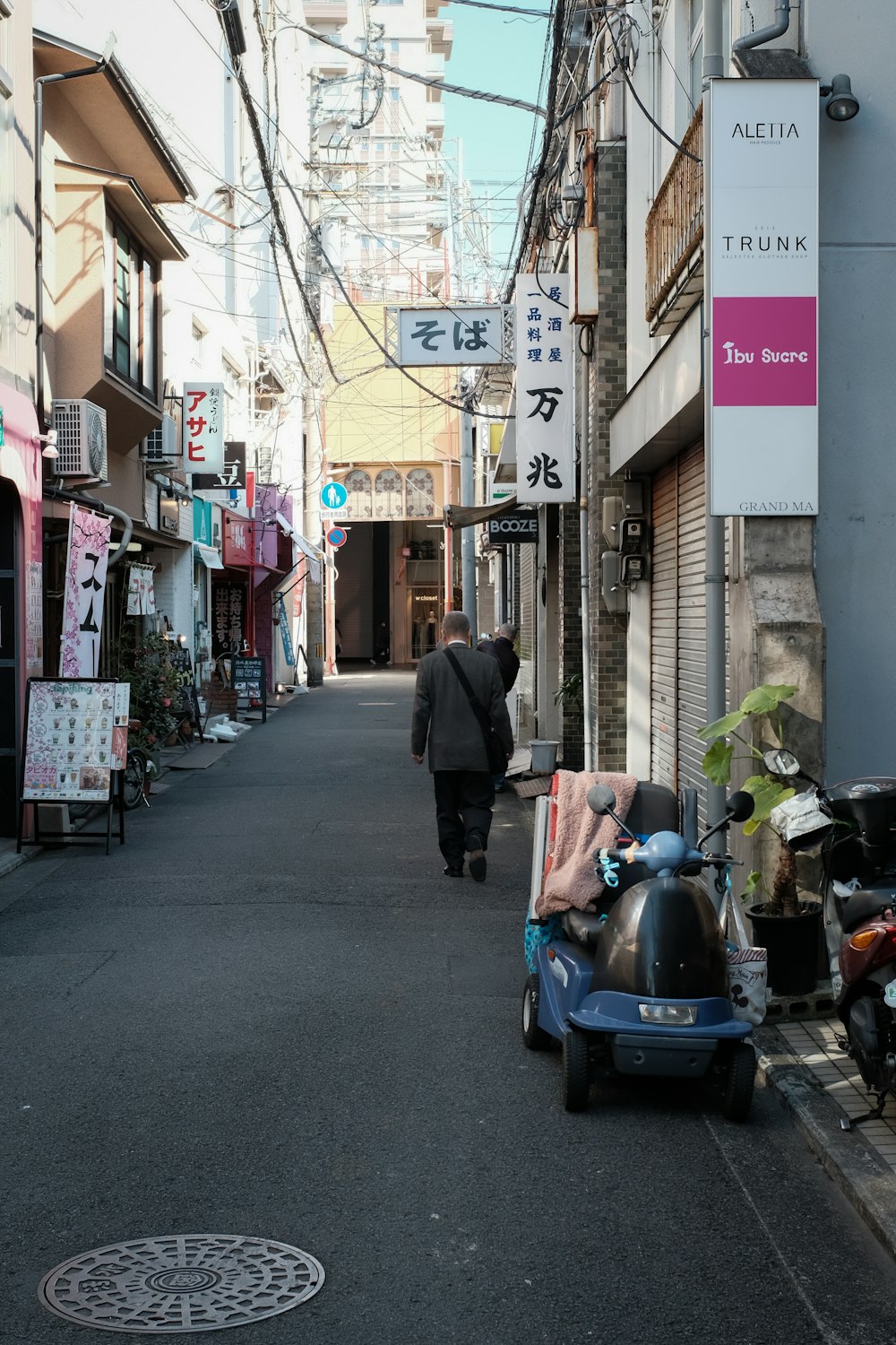 man in black jacket walking on street during daytime