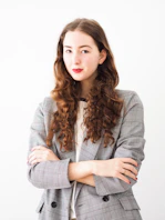 woman in gray cardigan and black and white striped dress