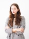 woman in gray cardigan and black and white striped dress