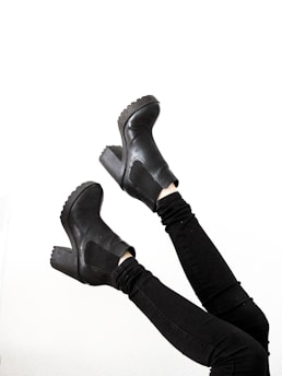 person wearing black leather boots