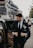 man in black suit jacket and black pants sitting on black car