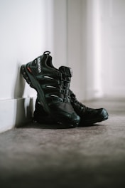 A pair of black athletic shoes on a gym floor.