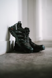 A pair of black athletic shoes on a gym floor.