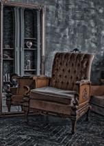brown wooden armchair beside white wall