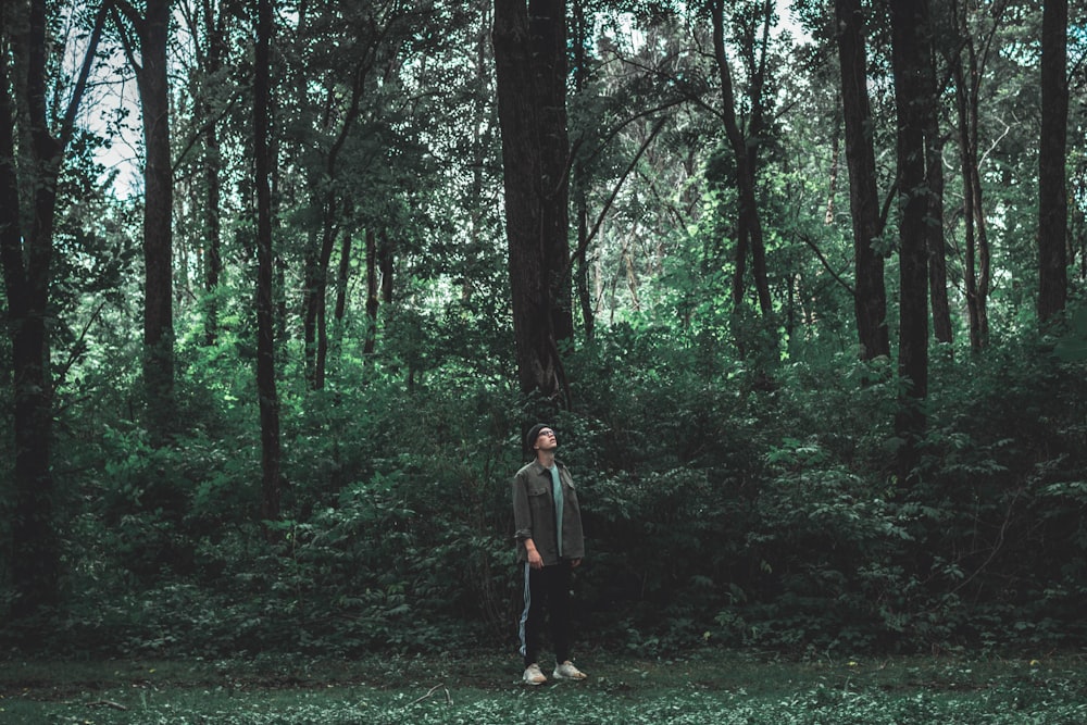 woman in brown jacket standing on forest during daytime