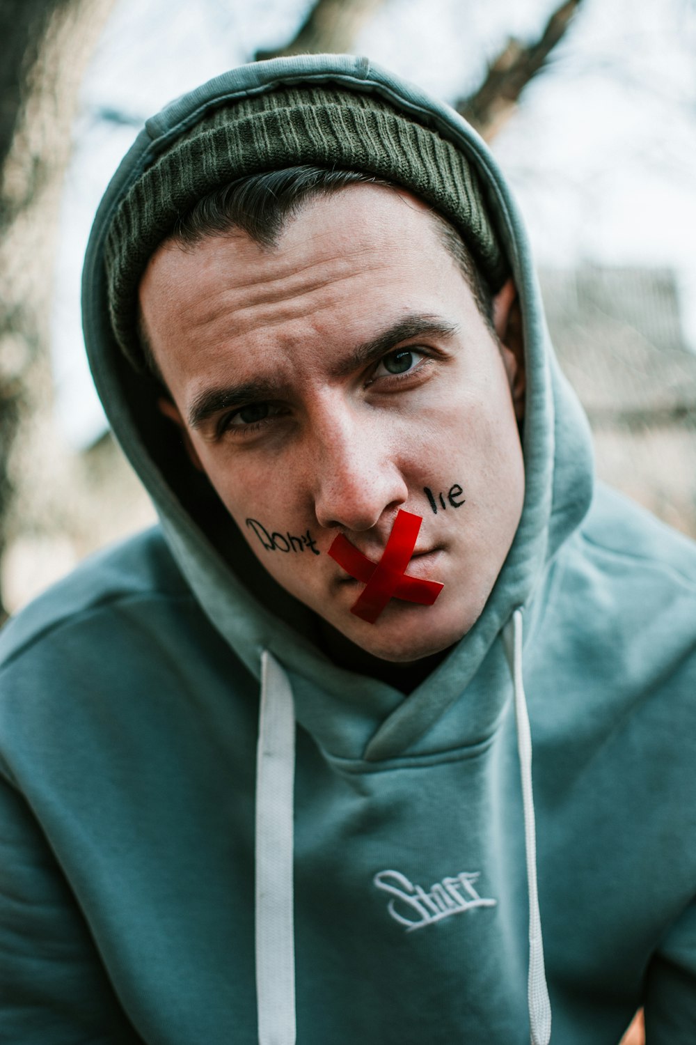 man in gray hoodie with red heart on his head