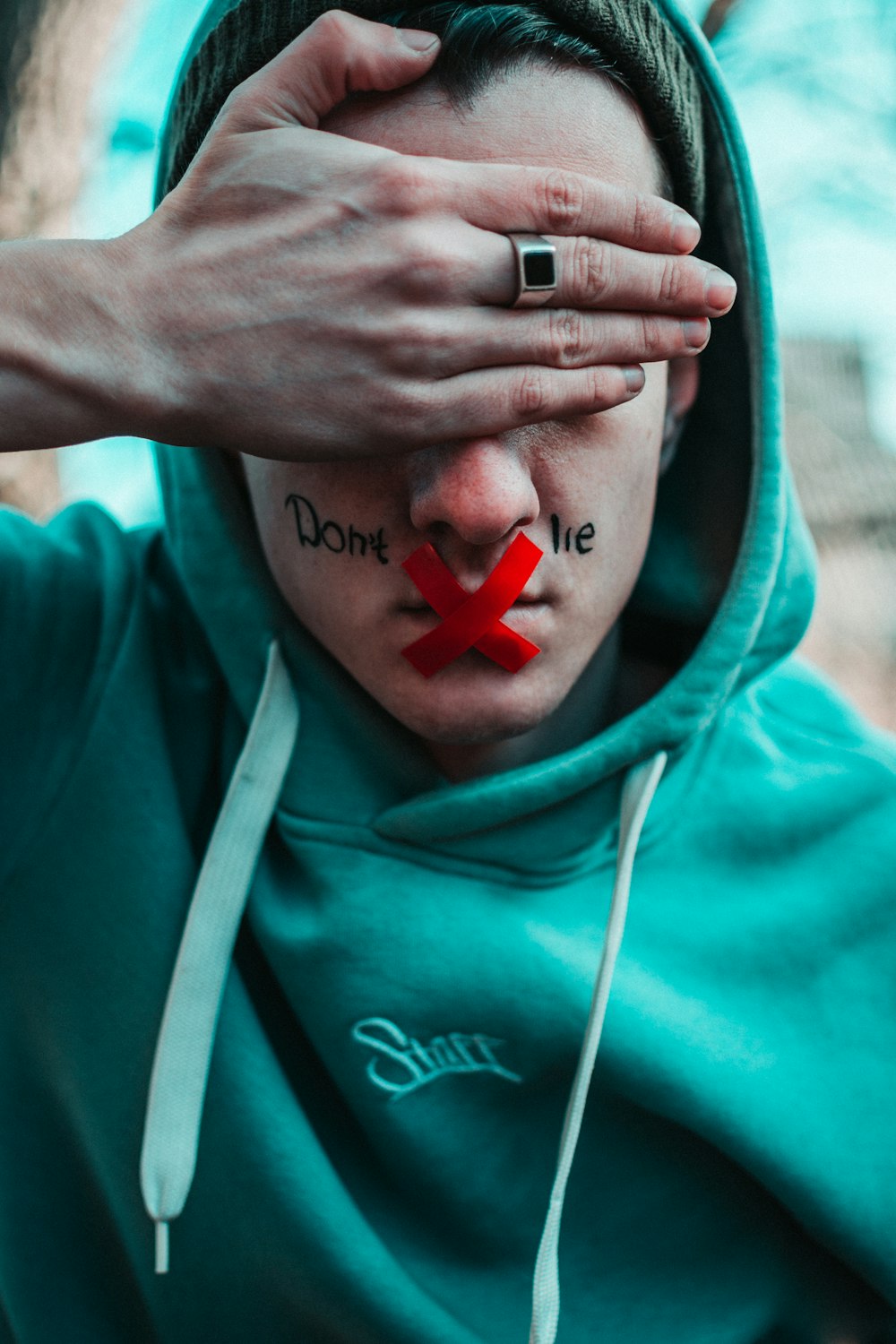 man in teal hoodie with i love you text