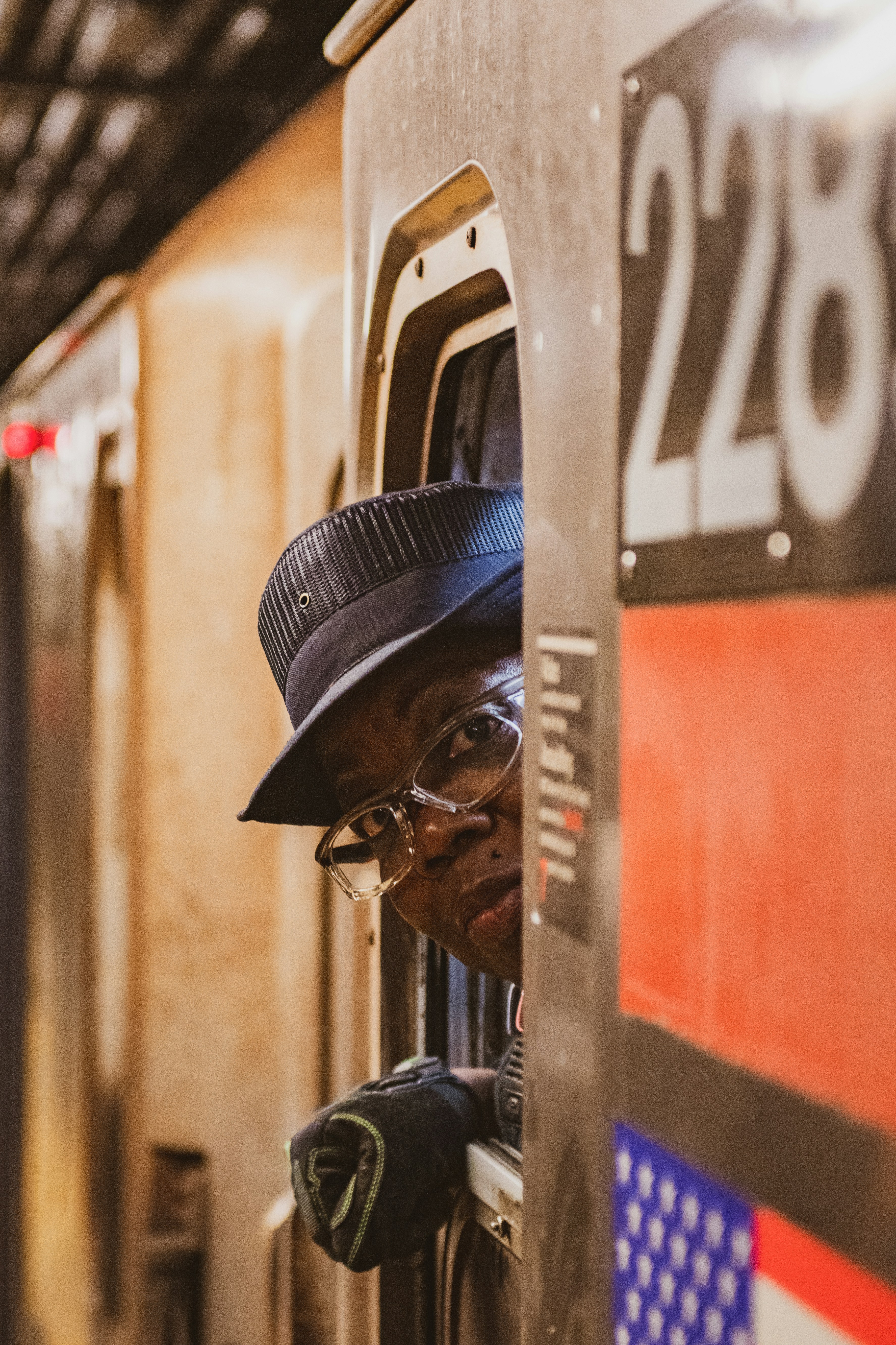 man in black leather jacket wearing black sunglasses and blue cap