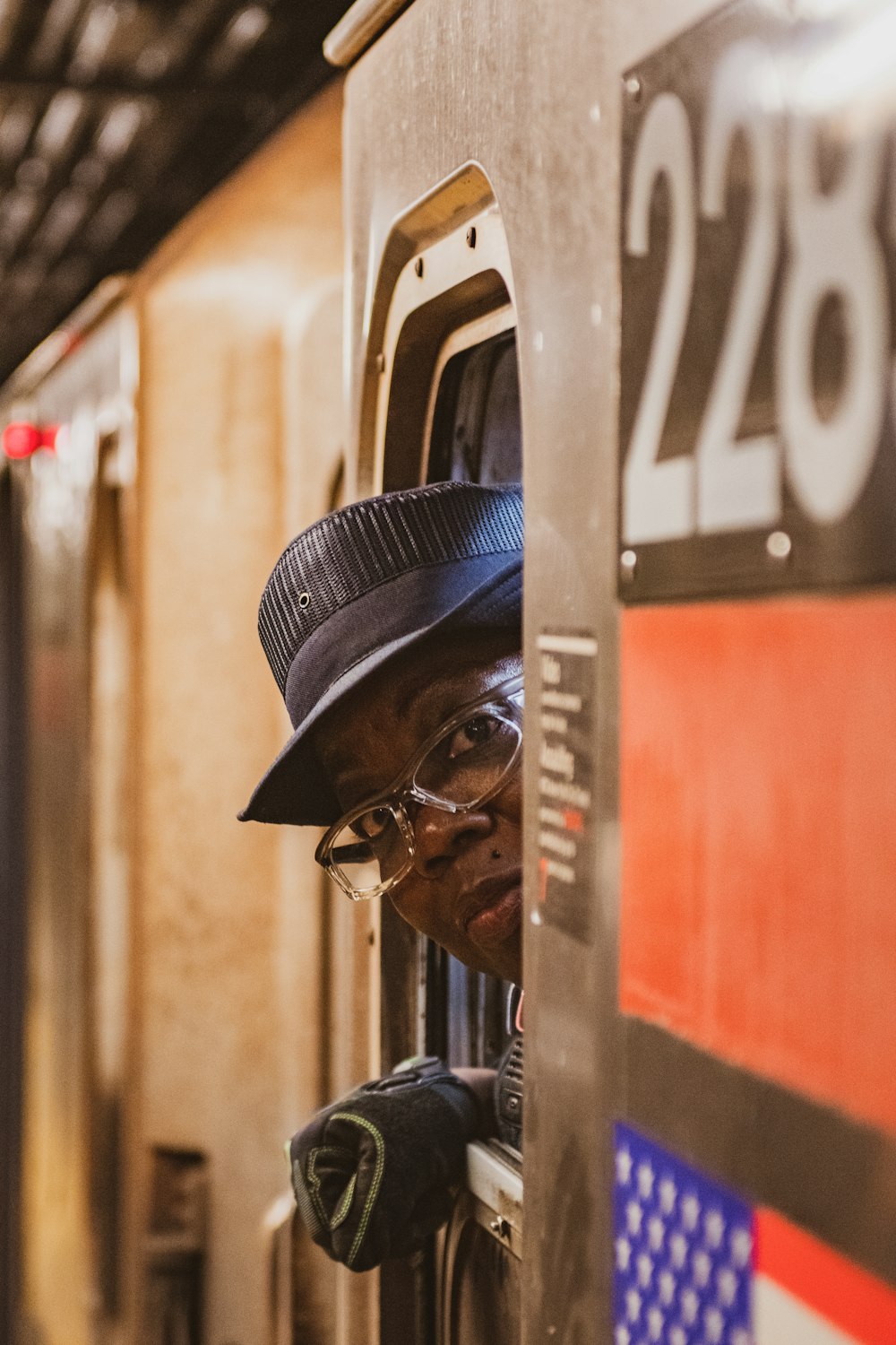 Homme en veste en cuir noir portant des lunettes de soleil noires et une casquette bleue