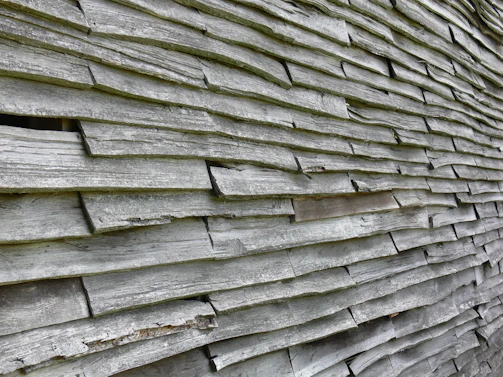 Close-up of sleek wood-plastic composite wall panels installed on a modern home's exterior, showcasing their texture and weatherproof finish.