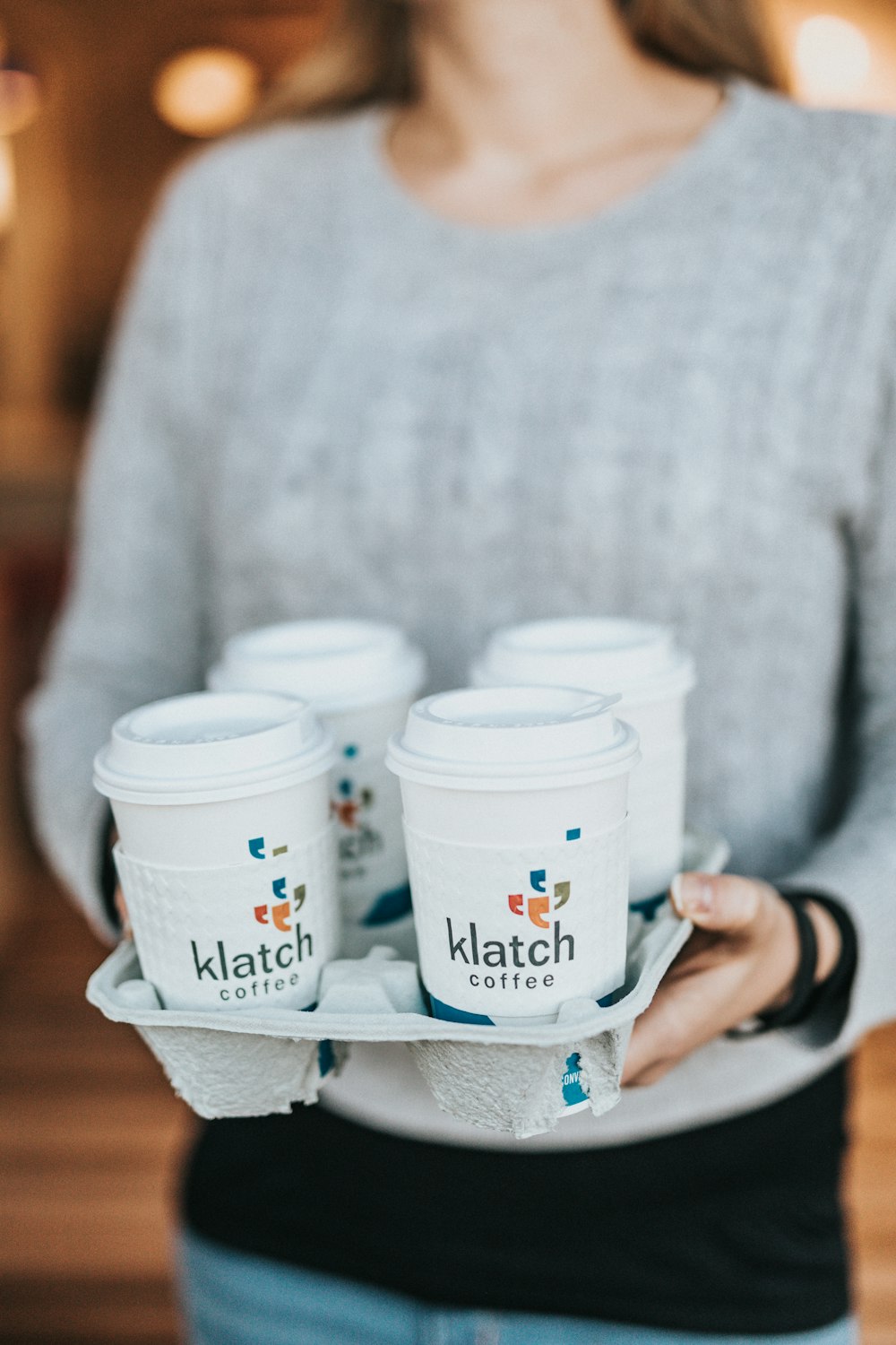 person holding white and blue disposable cups