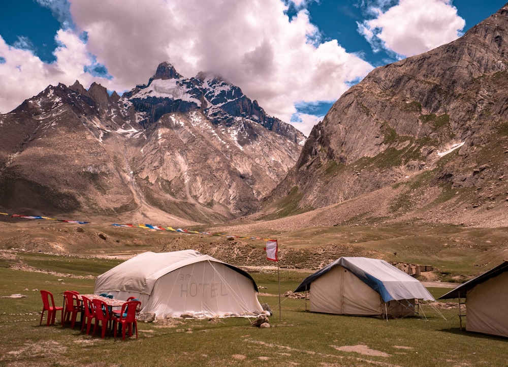 white tent near brown mountain under blue sky during daytime