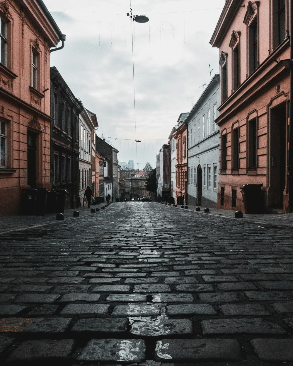 gray concrete road between brown concrete buildings during daytime