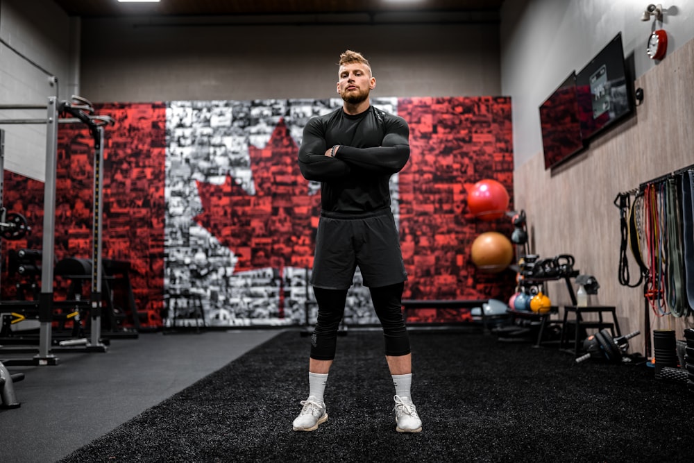 man in black jacket and black shorts standing on black carpet