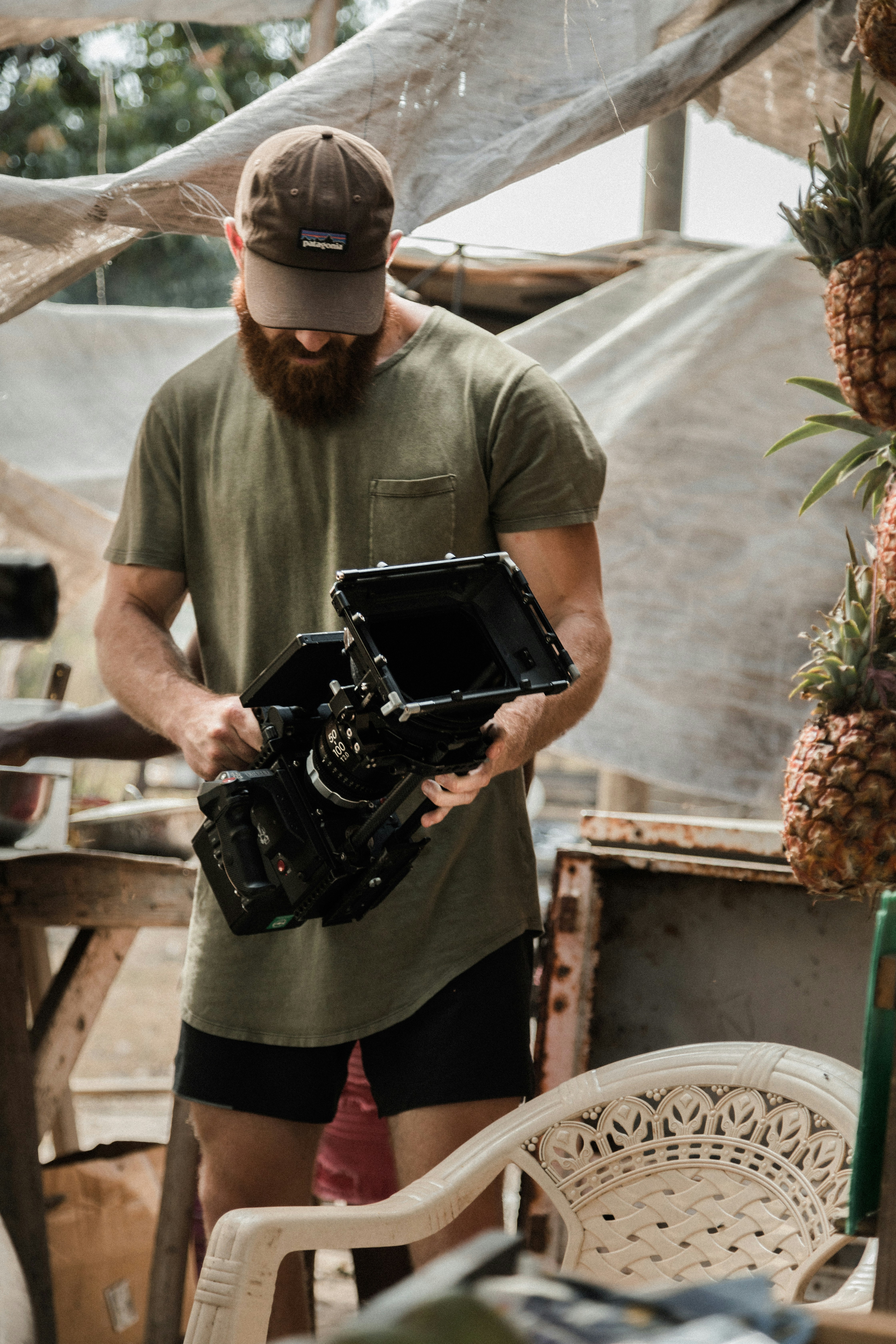 man in green t-shirt and black pants holding black dslr camera