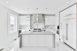 A sleek kitchen with modern appliances and marble countertops.