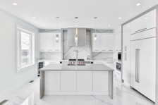 Modern kitchen area featuring sleek appliances and elegant marble countertops.