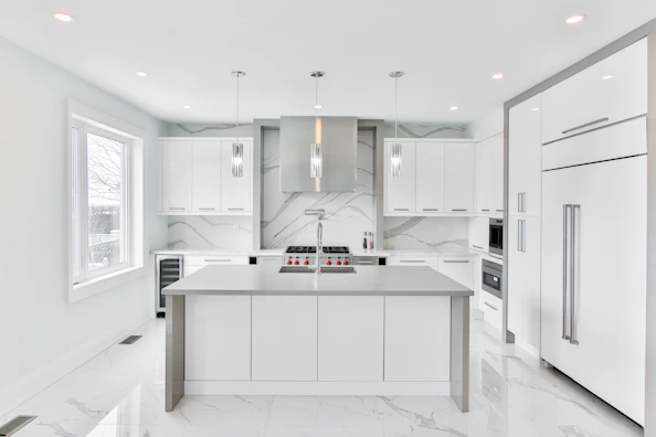 A sleek kitchen with modern appliances and marble countertops.
