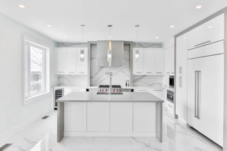 Modern minimalist renovated kitchen with sleek surfaces and natural light.