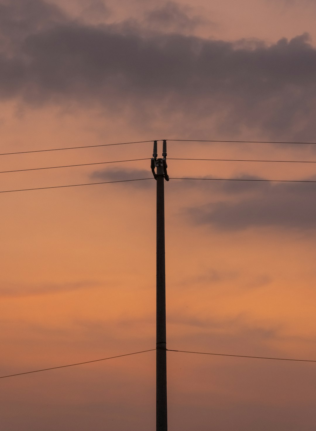 black electric post under gray sky