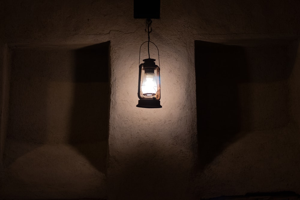 black framed pendant lamp turned on in a dark room
