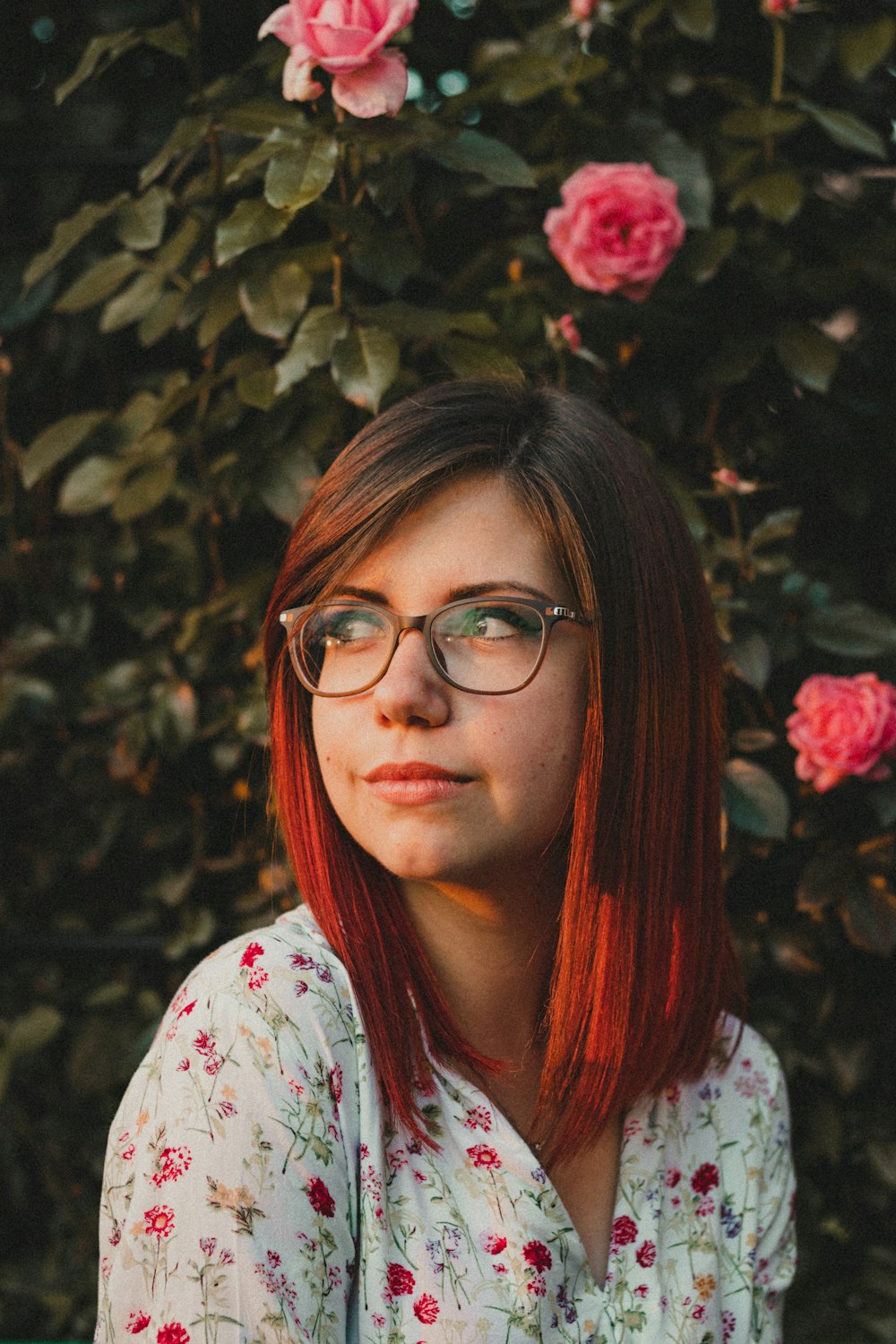 woman in white and pink floral shirt wearing eyeglasses