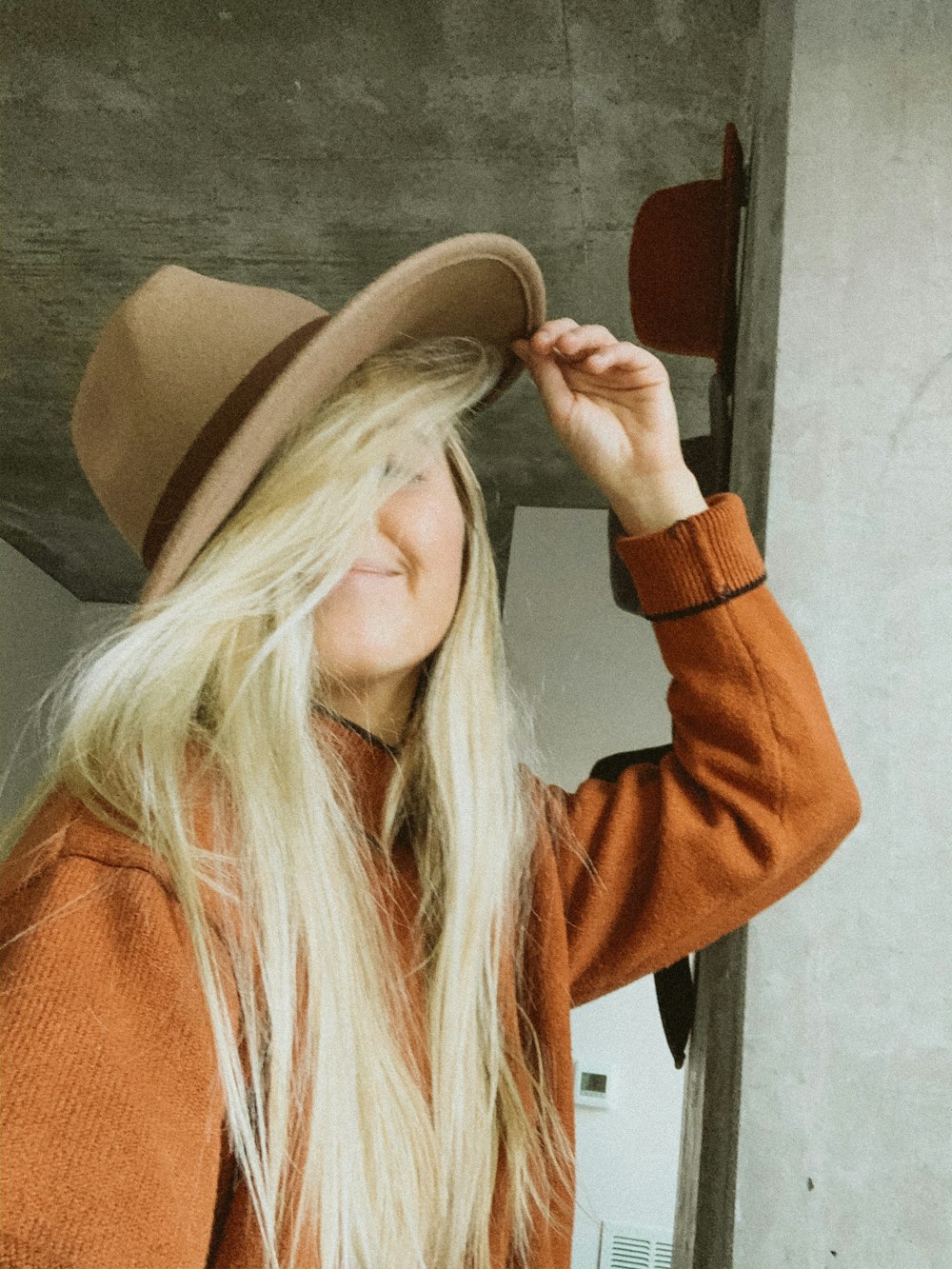 woman in brown cowboy hat and orange long sleeve shirt