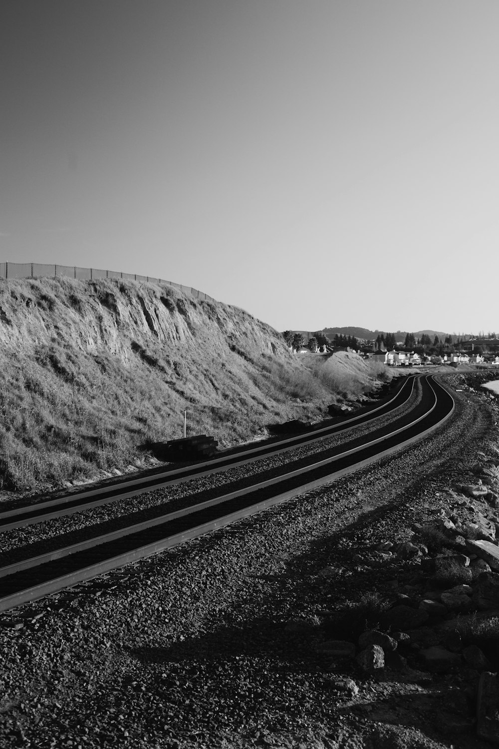 grayscale photo of train rail near mountain