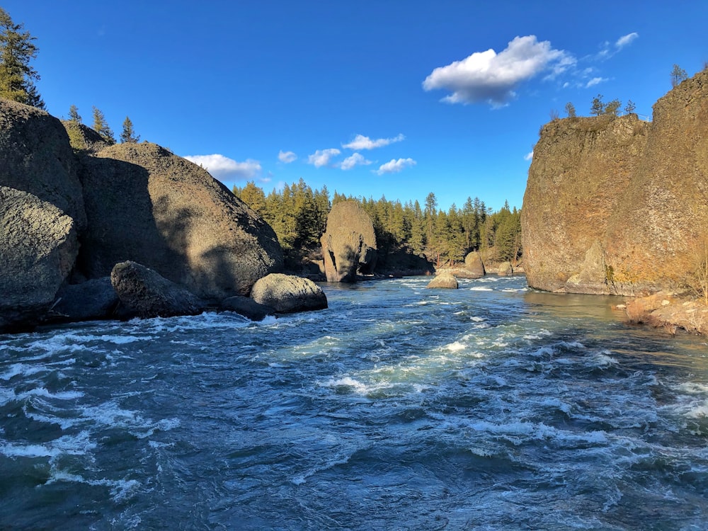 brown rock formation on body of water during daytime