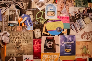 A collage of various music posters and album covers, featuring bands and artists such as Coldplay and OK Go. The image includes handwritten signatures and notes, along with various illustrations and graphics. There's a mix of vibrant and muted tones.