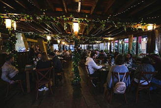 Cozy restaurant interior decorated for a lively event with guests enjoying food and drinks.