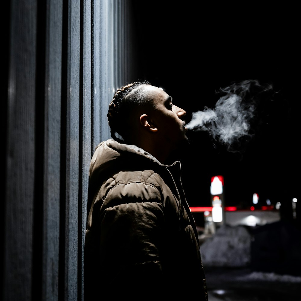 uomo in giacca nera che fuma
