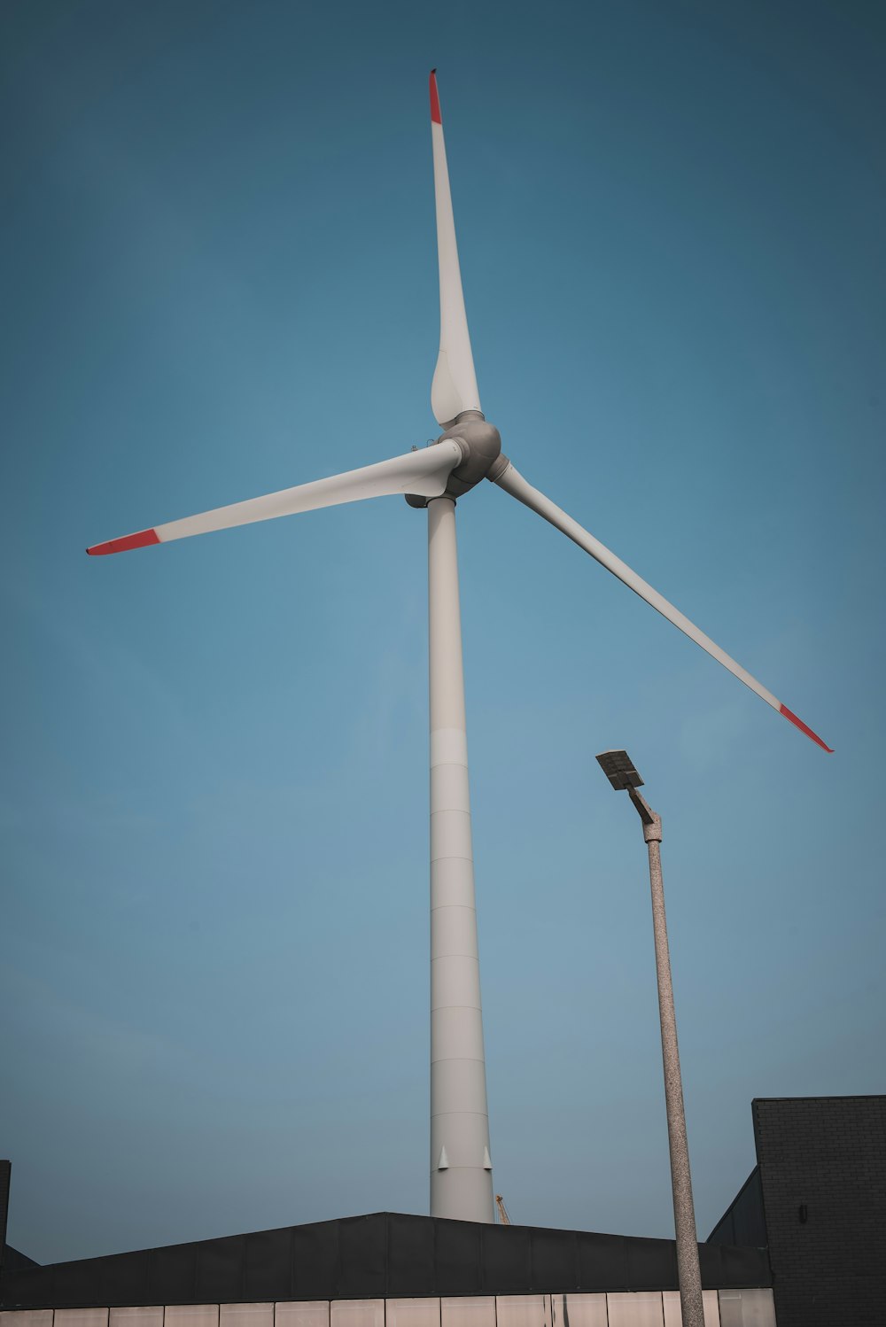 white wind turbine under blue sky during daytime