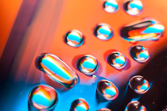 Close-up of vibrant ink droplets blending on a glossy surface, highlighting rich colors and smooth texture.