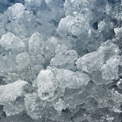 A close-up of ice cubes glistening in natural light.