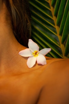 white flower on womans breast